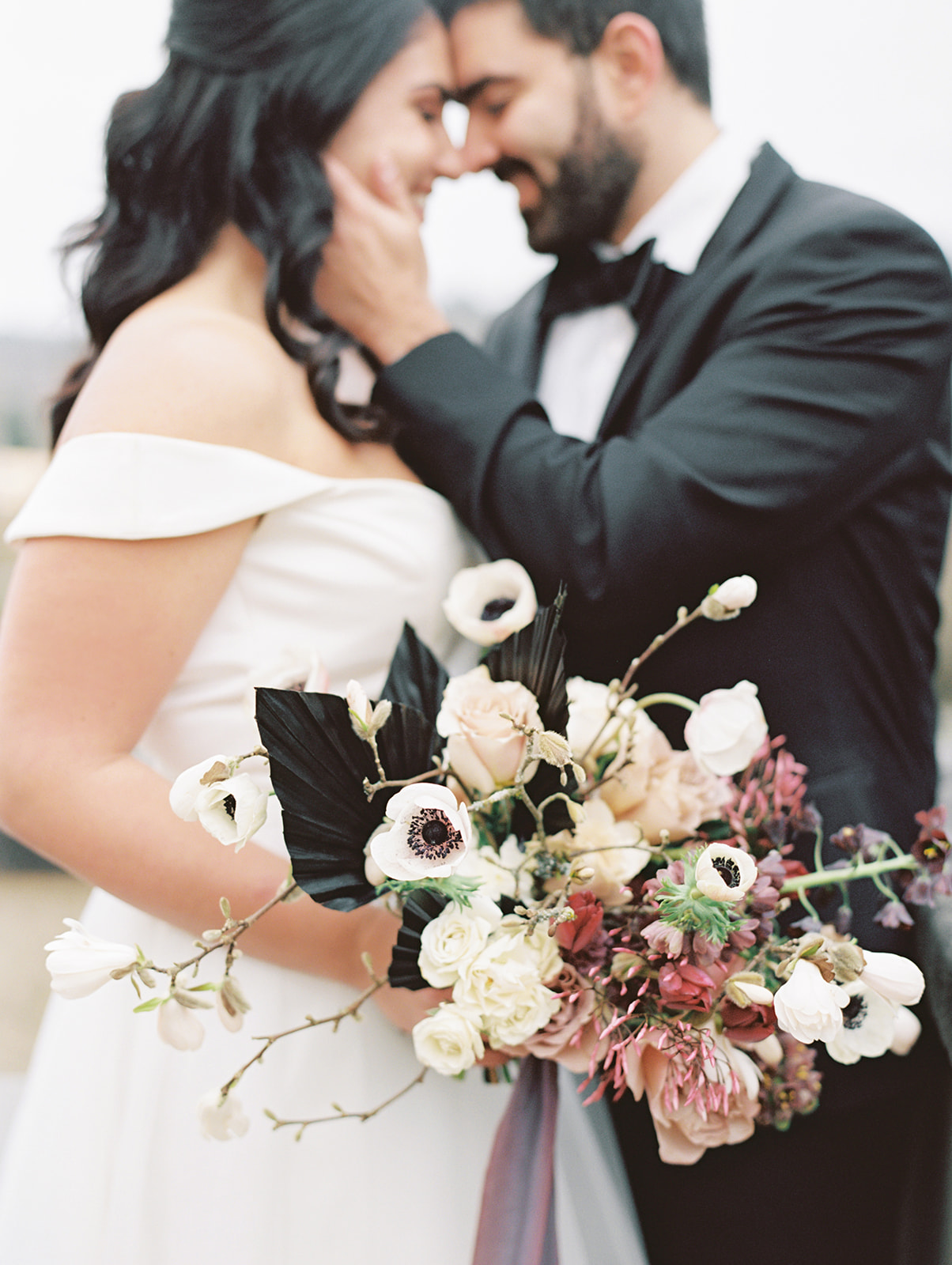 Chateau-Lill-Wedding-Bouquet-Closeup.jpg A couple embracing and holding a bouquet with delicate spring blooms at Chateau Lill