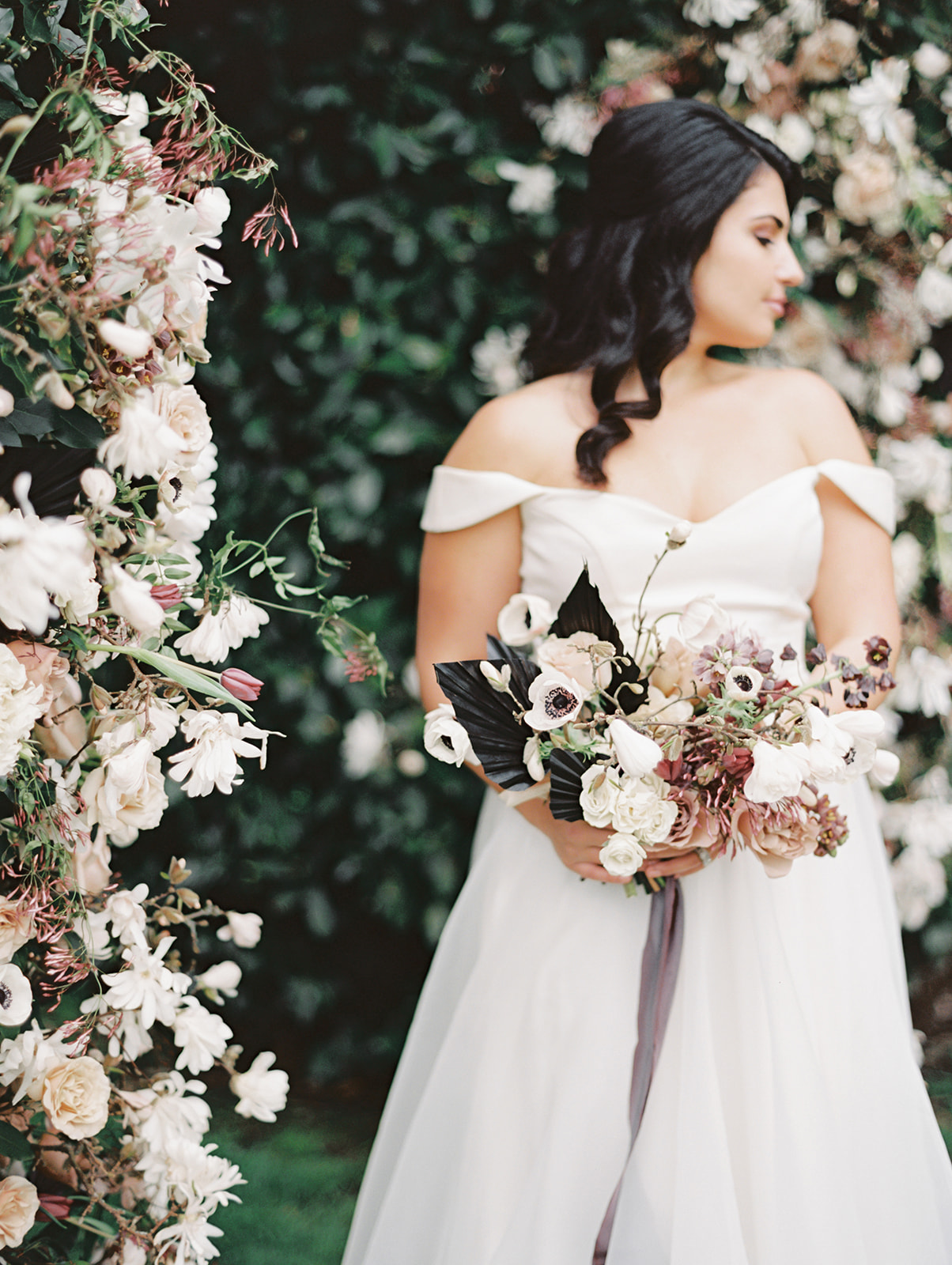 Chateau Lill Spring Editorial | Full Gallery The bride holding a bouquet in front of a garden hedge that was transformed into a large floral archway at Chateau Lill