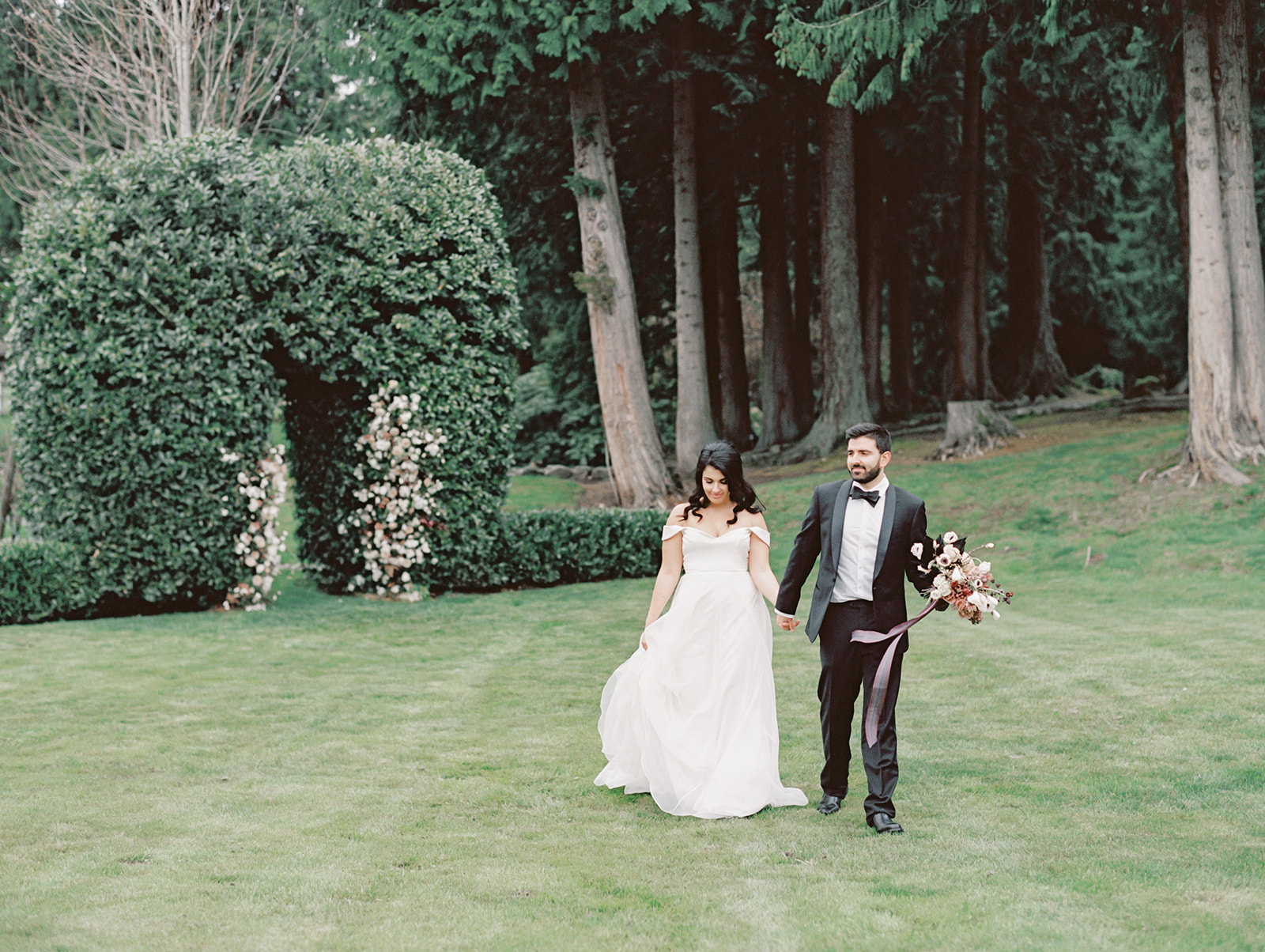 Chateau-Lill-Wedding-Bride-and-Groom-Lawn.jpg A bride and groom walking across the lawn of Chateau Lill holding hands