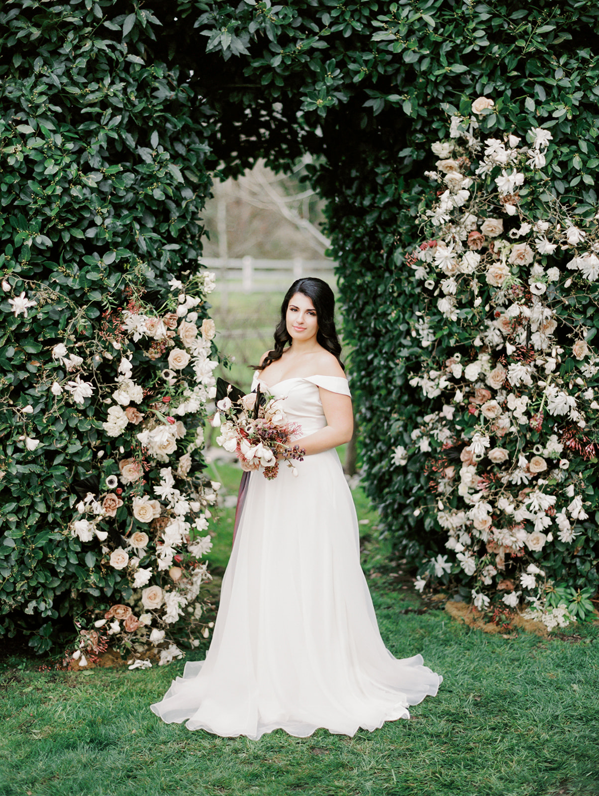 Chateau-Lill-Wedding-Bride-at-Garden-Hedge.jpg the bride standing in front of a floral arch installation in Chateau Lill, holding a bouquet