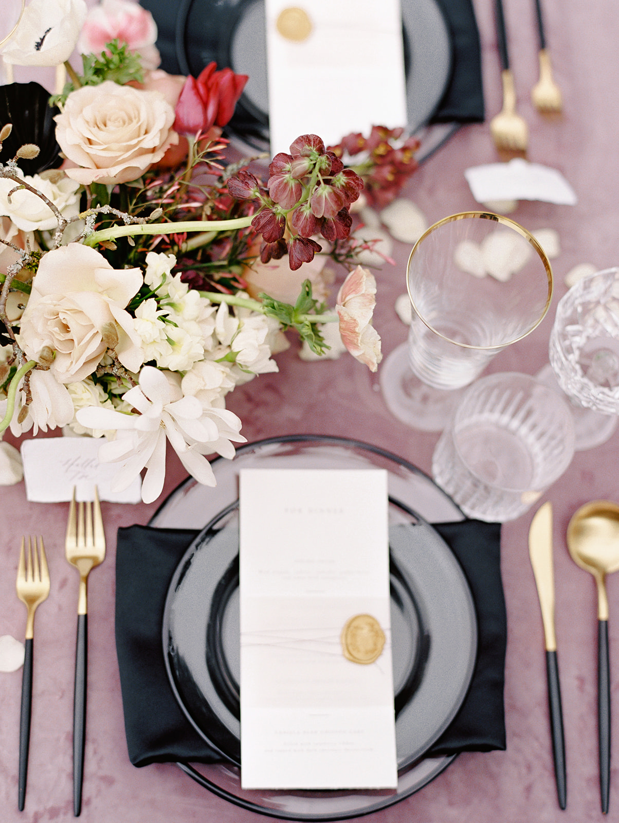 Chateau-Lill-Wedding-Sweetheart-Table-Place-Setting.jpg A table with mauve velvet linen, spring floral centerpiece, and black and gold place settings