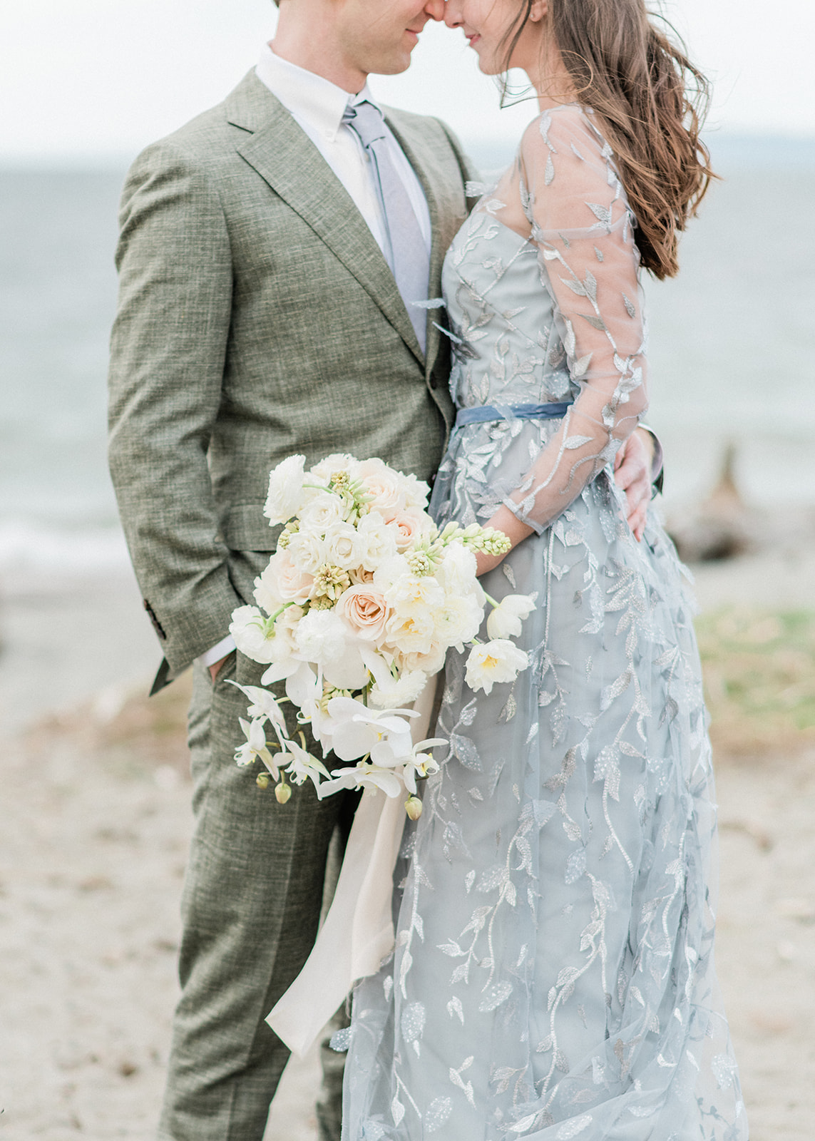 Discovery-Park-Elopement-White-Orchid-Bouquet.jpg Couple holding white orchid bouquet with blush ribbon in wind