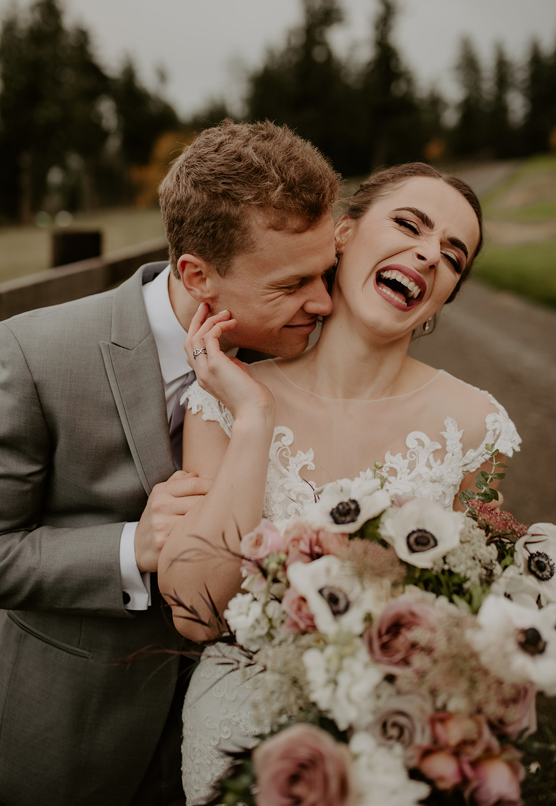 Kelley-Farm-Wedding-Couple-Laughing.jpg Couple laughing and embracing while holding bouquet