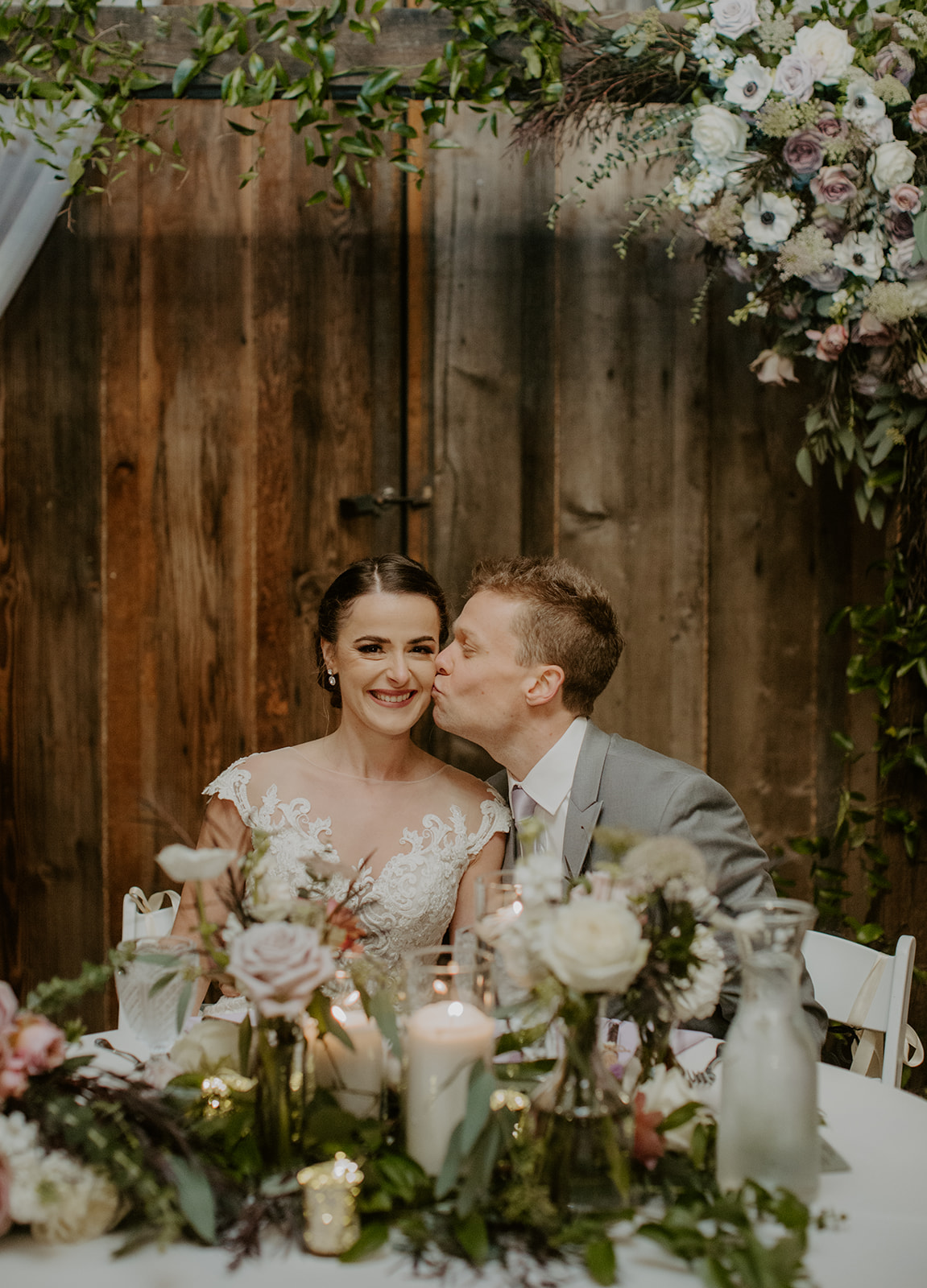 Kelley-Farm-Wedding-Sweetheart-Table.jpg The sweetheart table with couple kissing