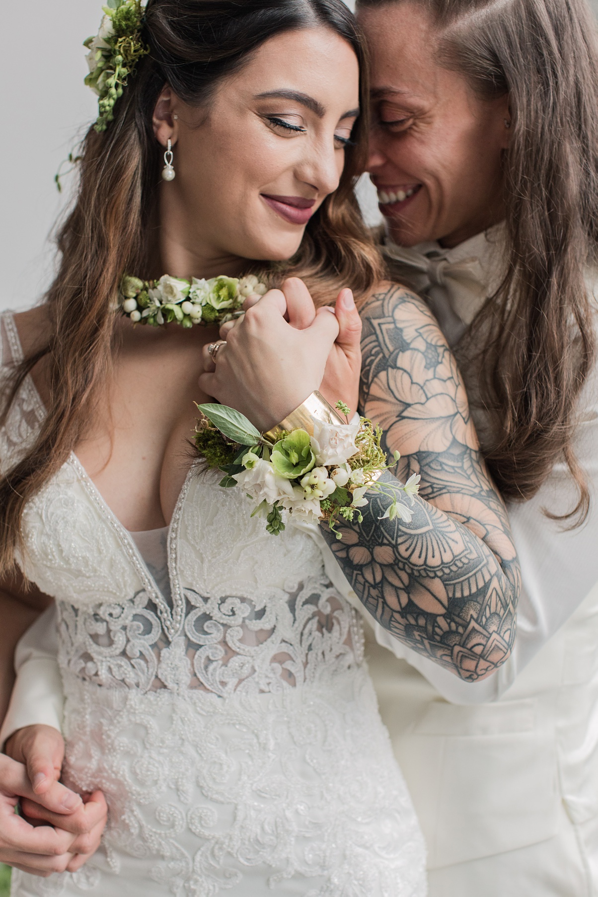 Brides embracing on their wedding day