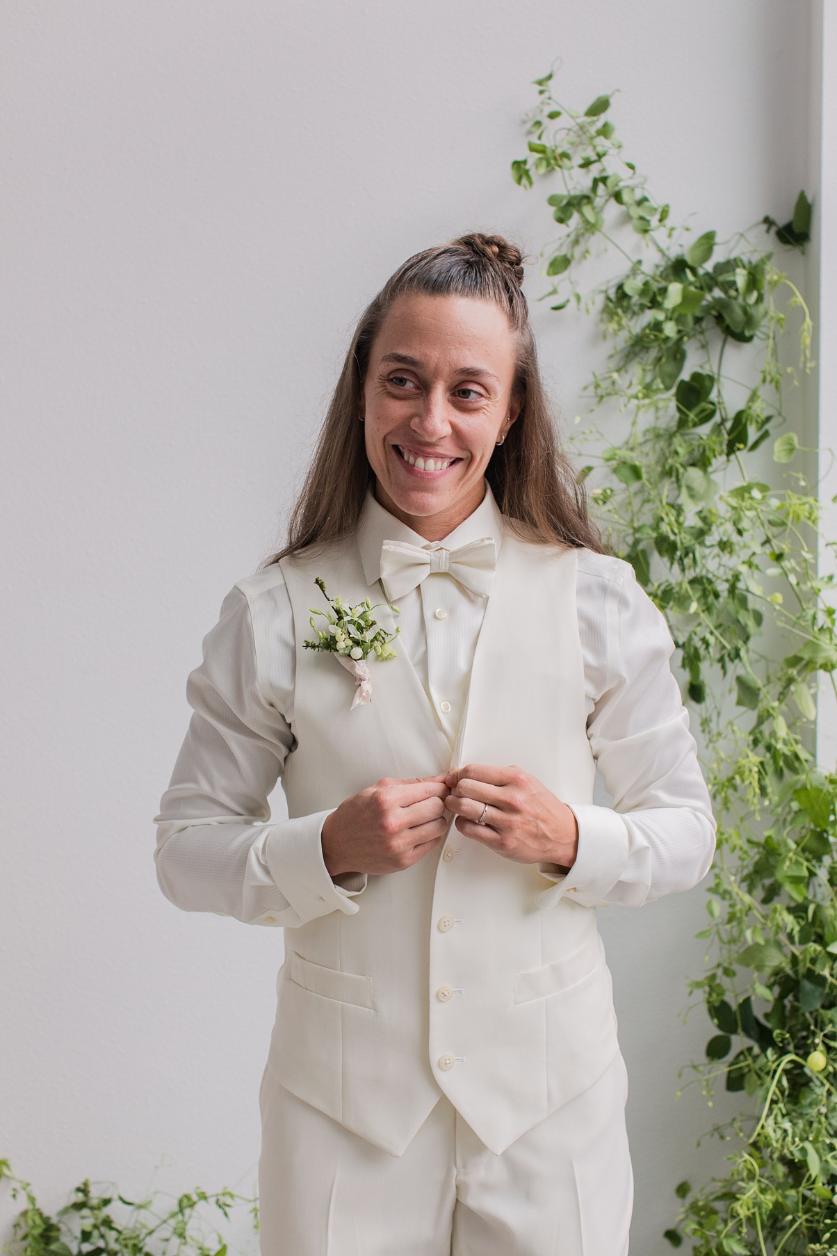 A bride getting ready standing in front of a floral installation
