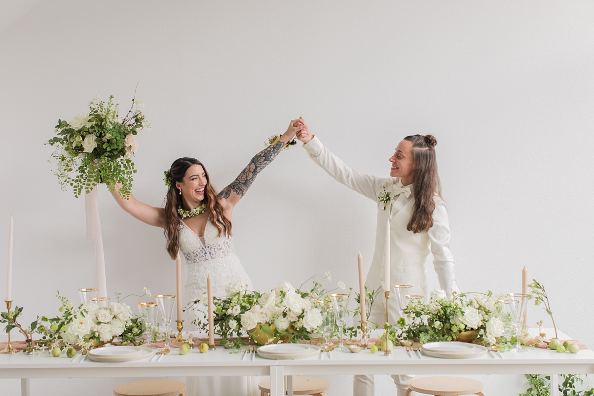 Brides holding hands and dancing after their ceremony