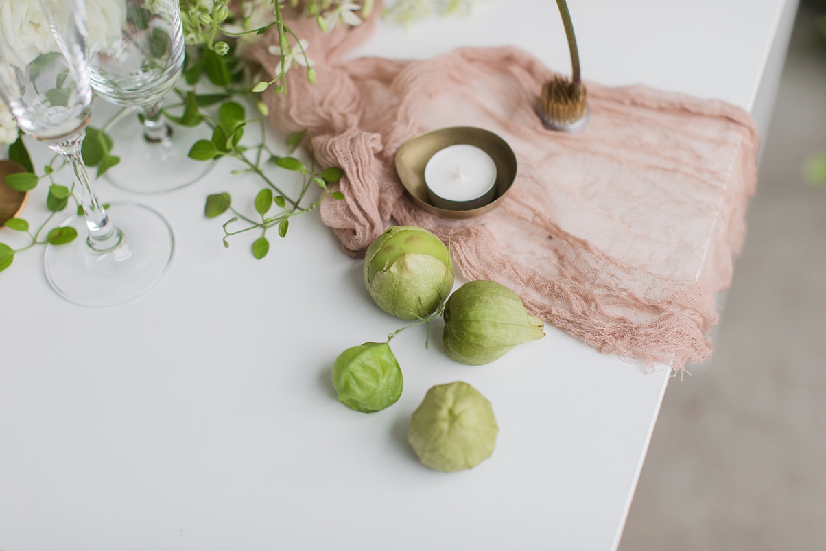 Table details with table runner, candles, and tomatillos