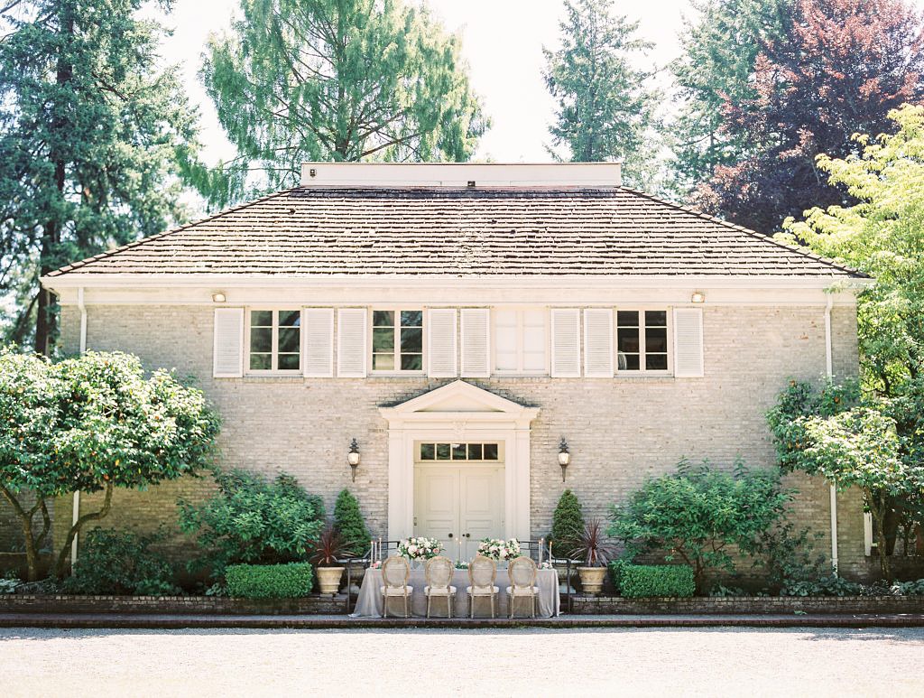 Folk Art Flowers Best Outdoor Wedding Venues in Seattle_0011 A large house (Lakewold Gardens) with a table set for a wedding in front of it