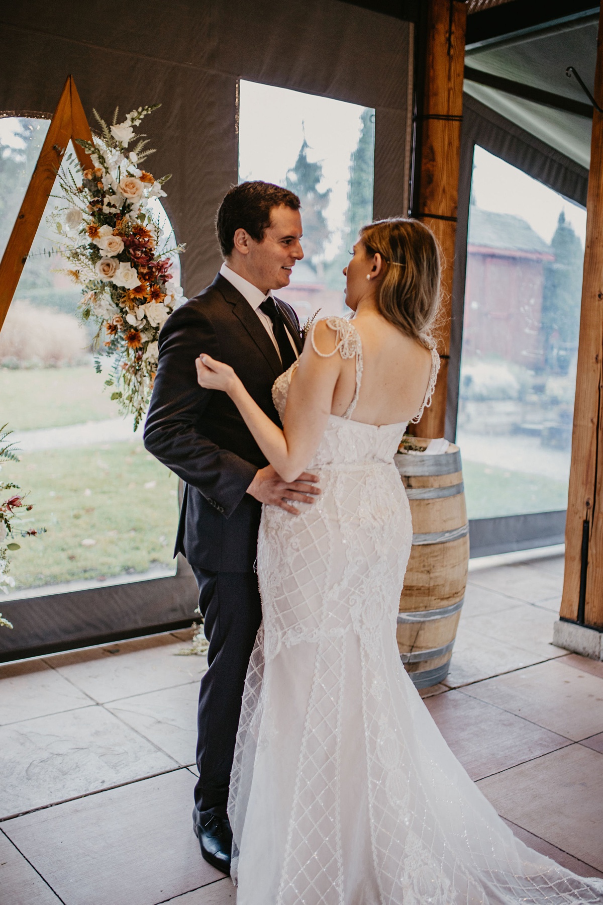 Willows-Lodge-Wedding-First-Look the bride and groom embracing in front of the floral arch for their first look