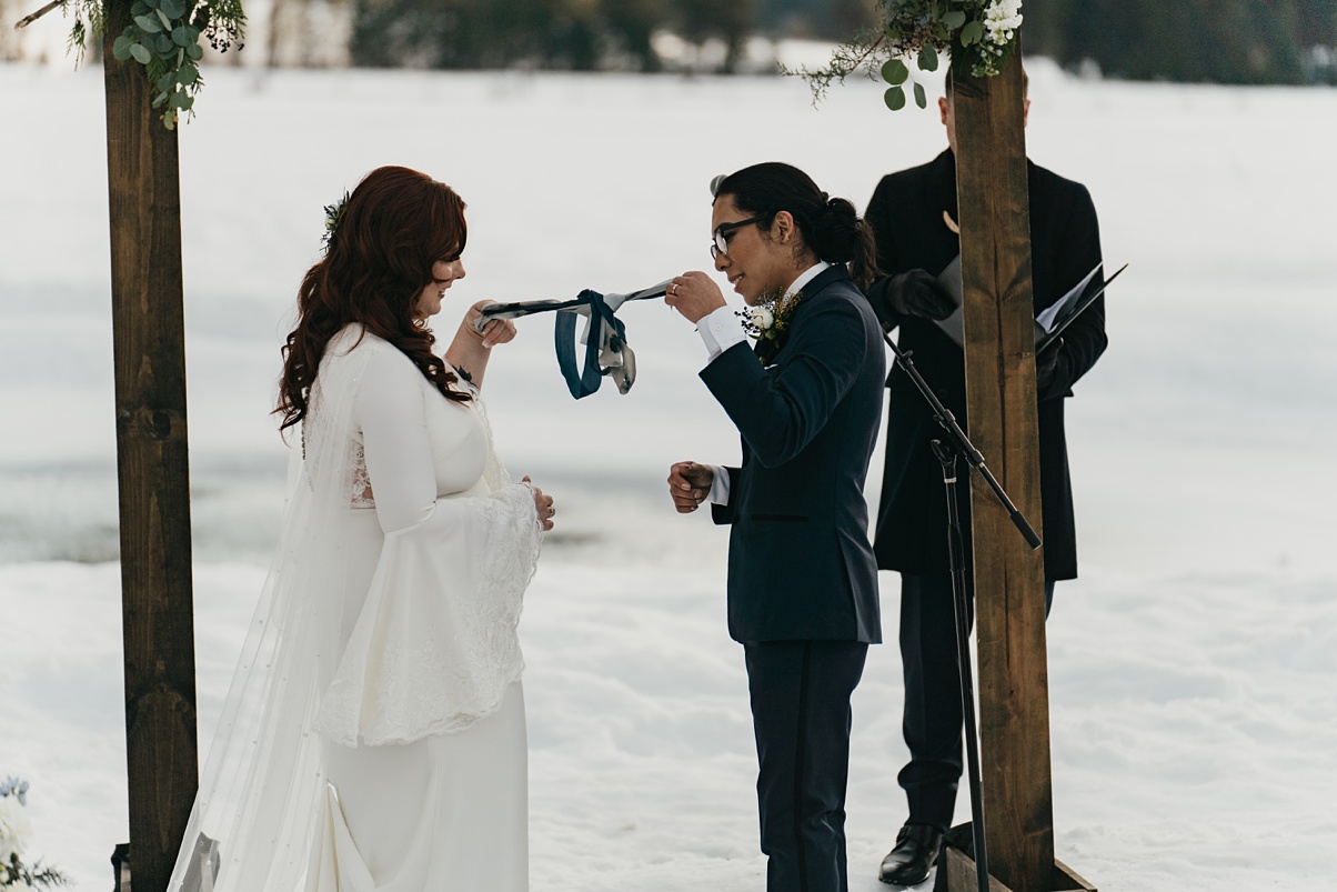 The couple literally ties the knot with silk ribbon from their handfasting ceremony