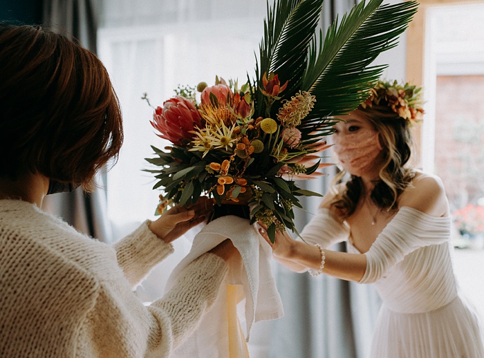 Mom hands over the bouquet to the bride