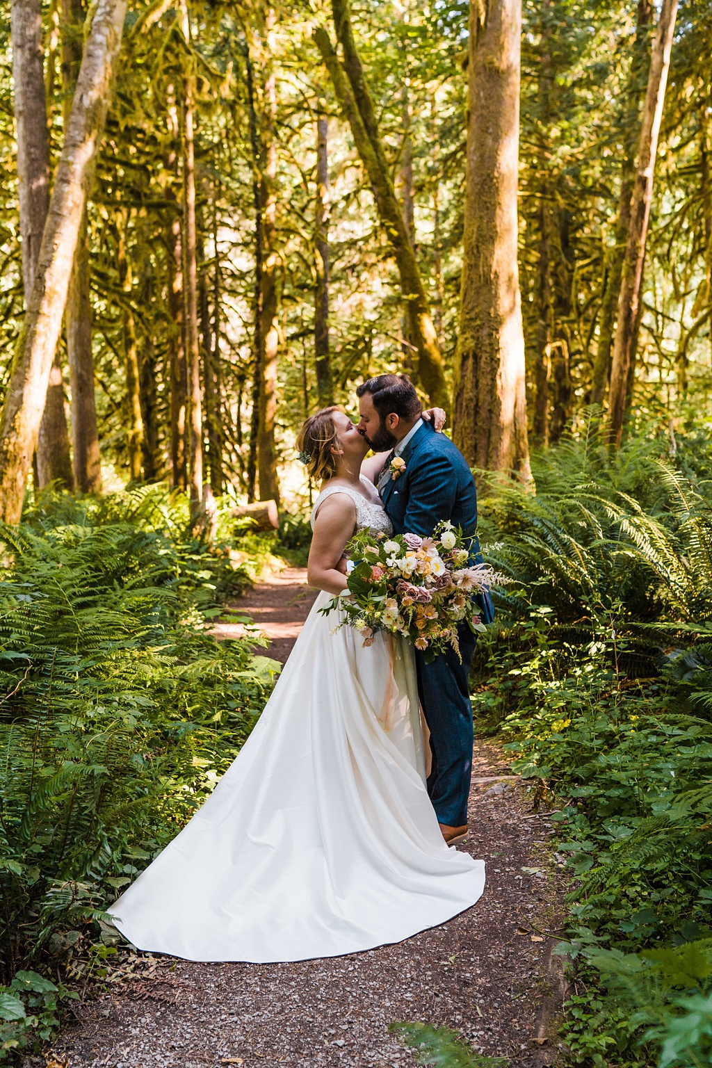 Mountain-Wedding-with-Vibrant-Summer-Blooms-Kissing-in-Woods The couple kissing in the woods
