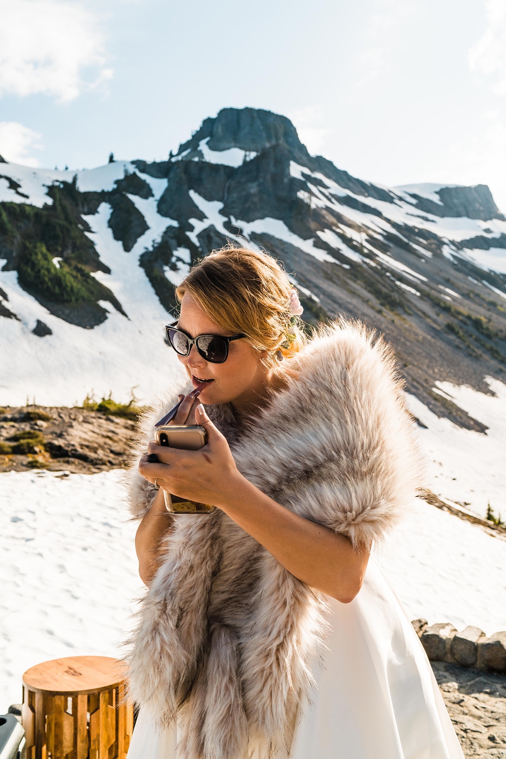 Mountain-Wedding-with-Vibrant-Summer-Blooms-Makeup The bride touches up her makeup at the mountain