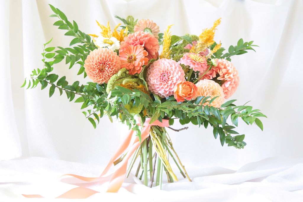 a dahlia bouquet with colorful dahlias, garden roses, and greenery