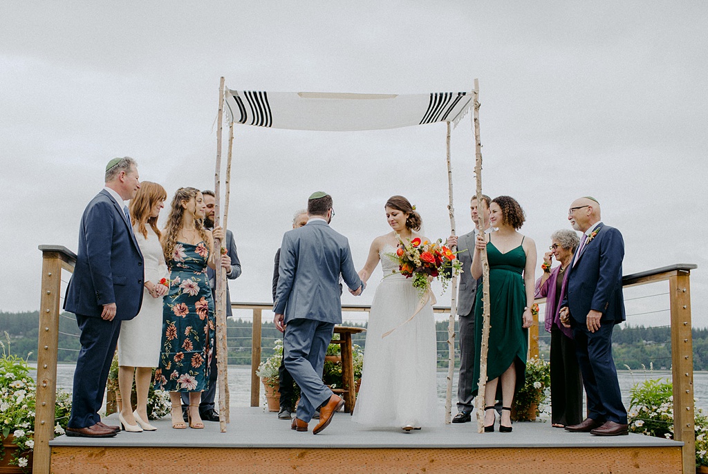 Bloom-Poet-Seattle-Wedding-Florist-Kiana-Lodge-Wedding-Ceremony The bride and groom with their human-powered chuppah at Kiana Lodge