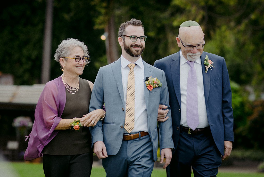 Bloom-Poet-Seattle-Wedding-Florist-Kiana-Lodge-Wedding-Groom-Walking The groom being walked to the ceremony at a Kiana Lodge wedding