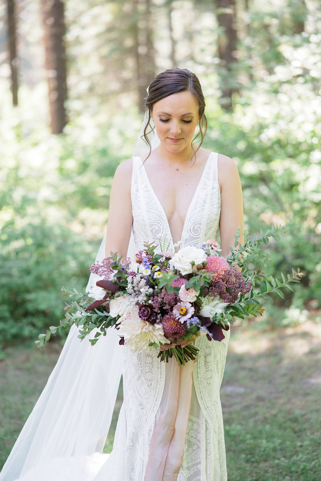Nicole and Adam The bride looks down at her wedding bouquet at Tierra Retreat Center